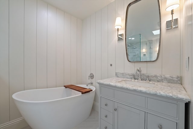 full bath with a shower with shower door, vanity, and a freestanding tub