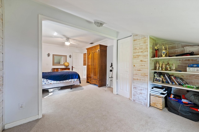 carpeted bedroom featuring ornamental molding, wooden walls, and ceiling fan