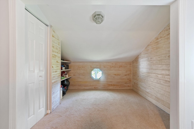 bonus room with wooden walls, vaulted ceiling, and light carpet