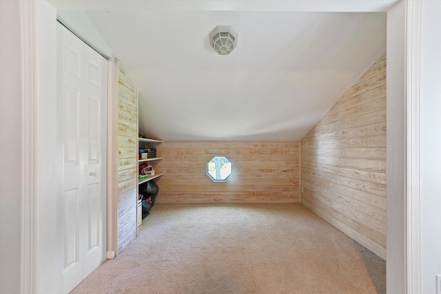 additional living space with wood walls, carpet, and vaulted ceiling