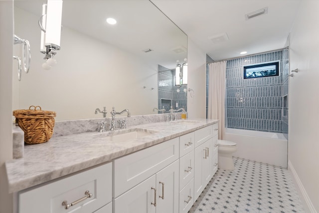 full bath featuring toilet, visible vents, a sink, and double vanity
