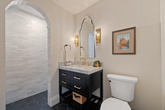 bathroom with vanity, a shower, toilet, and tile patterned floors