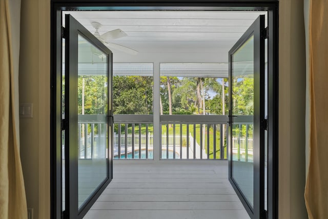 unfurnished sunroom with ceiling fan