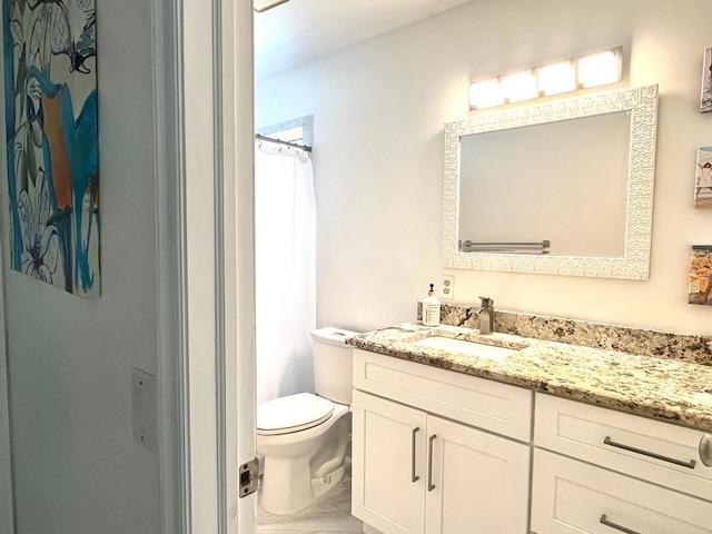 bathroom with walk in shower, toilet, and vanity