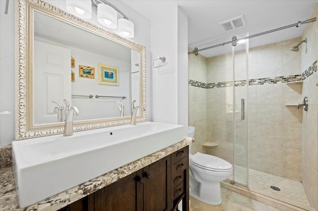 bathroom with vanity, toilet, tile patterned floors, and walk in shower