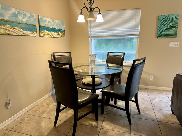 dining space featuring light tile patterned floors and an inviting chandelier