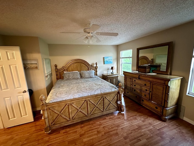bedroom featuring wood finished floors, a ceiling fan, and a textured ceiling