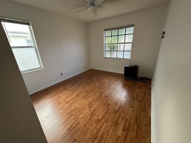 unfurnished room with a textured ceiling, hardwood / wood-style flooring, and ceiling fan