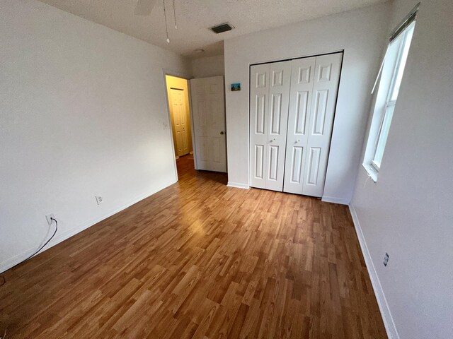 unfurnished bedroom with ceiling fan, light hardwood / wood-style flooring, and a textured ceiling