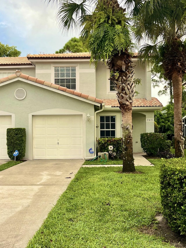 view of front facade with stucco siding, a front yard, and concrete driveway