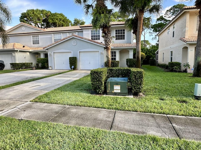view of front of home with concrete driveway, a tile roof, stucco siding, a front lawn, and a garage