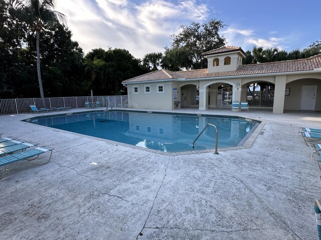 pool with a patio and fence
