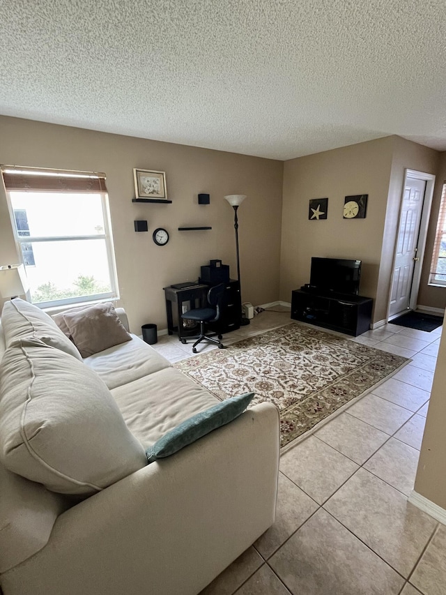 living area with light tile patterned flooring, baseboards, and a textured ceiling