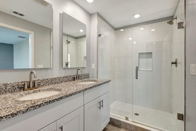 bathroom featuring vanity and a shower with door