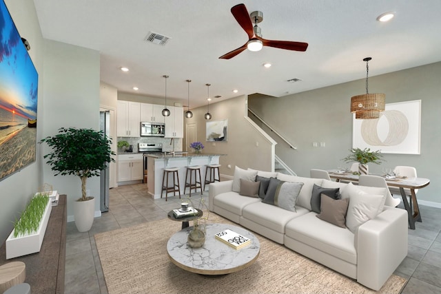 living room featuring ceiling fan and light tile patterned flooring