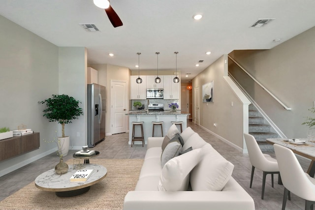 tiled living room with ceiling fan