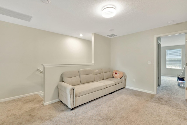 carpeted living room featuring a textured ceiling