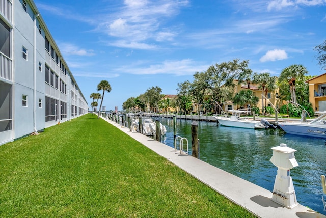 view of dock featuring a lawn and a water view