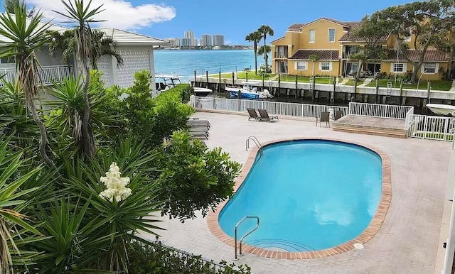 view of swimming pool with a water view and a patio