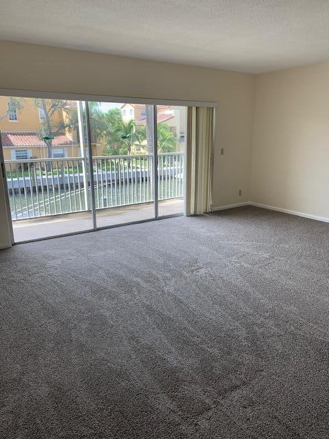 empty room with a textured ceiling and carpet floors