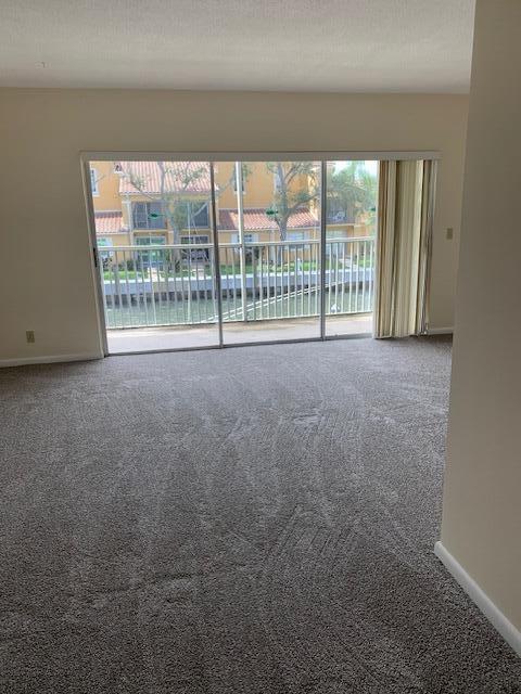 carpeted spare room with a textured ceiling