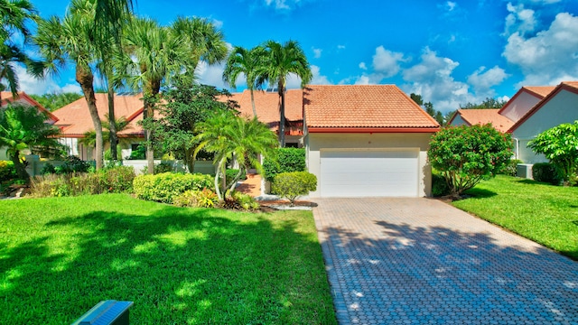 view of front facade with central air condition unit, a garage, and a front yard