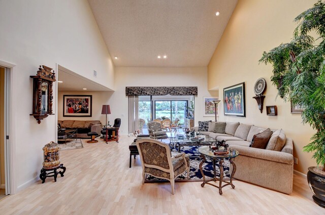 living room featuring light hardwood / wood-style flooring and high vaulted ceiling