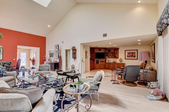 living room with high vaulted ceiling and light hardwood / wood-style floors