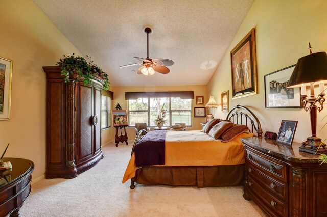 carpeted bedroom with a textured ceiling, vaulted ceiling, and ceiling fan