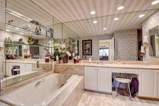 bathroom with vanity and tiled bath