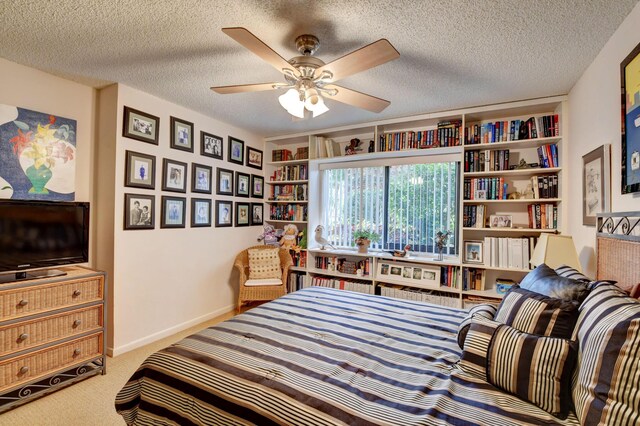 bedroom with a textured ceiling, ceiling fan, and carpet floors