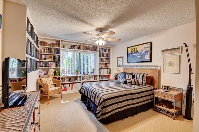 carpeted bedroom with a textured ceiling and ceiling fan