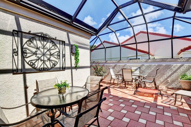 view of patio featuring glass enclosure