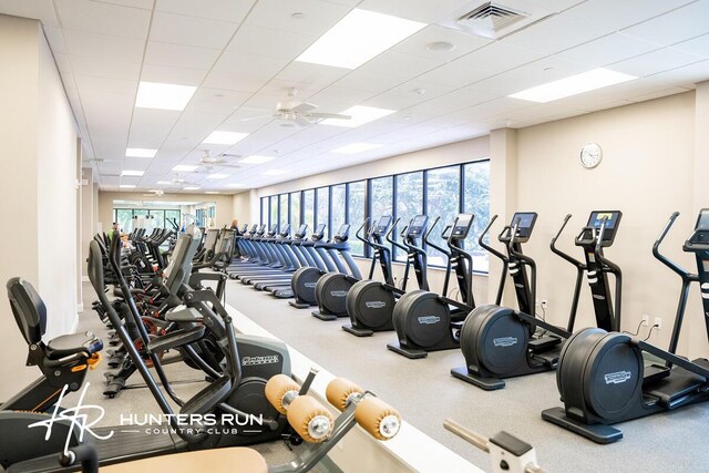 gym featuring ceiling fan and a drop ceiling