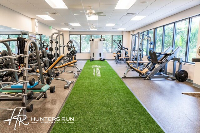 workout area with ceiling fan and a drop ceiling