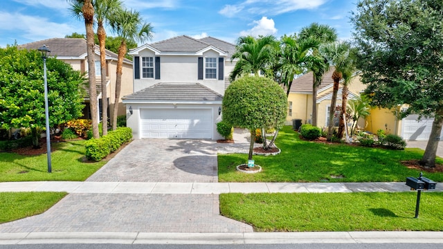 view of front of home with a garage, central AC, and a front yard