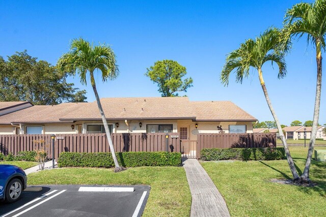 single story home featuring a fenced front yard, uncovered parking, and stucco siding