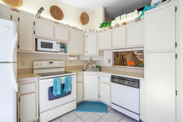 kitchen with sink, white appliances, and white cabinetry