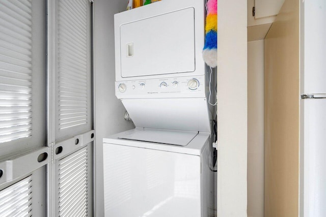 clothes washing area with stacked washer / dryer