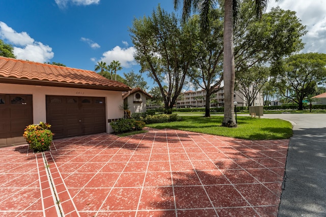 exterior space with a garage and a lawn