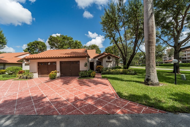 mediterranean / spanish-style home featuring a front yard and a garage