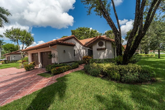 mediterranean / spanish-style house featuring a front yard and a garage