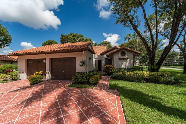 mediterranean / spanish-style home featuring a front yard and a garage