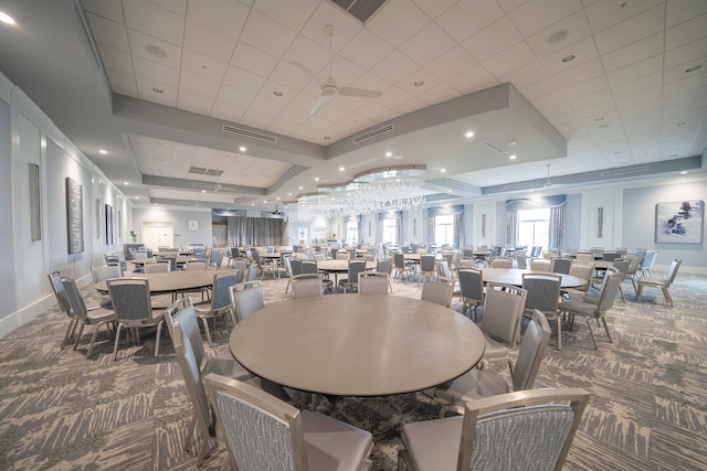 dining area with carpet, a tray ceiling, and a paneled ceiling