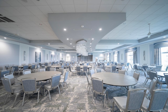 carpeted dining space with a drop ceiling and an inviting chandelier