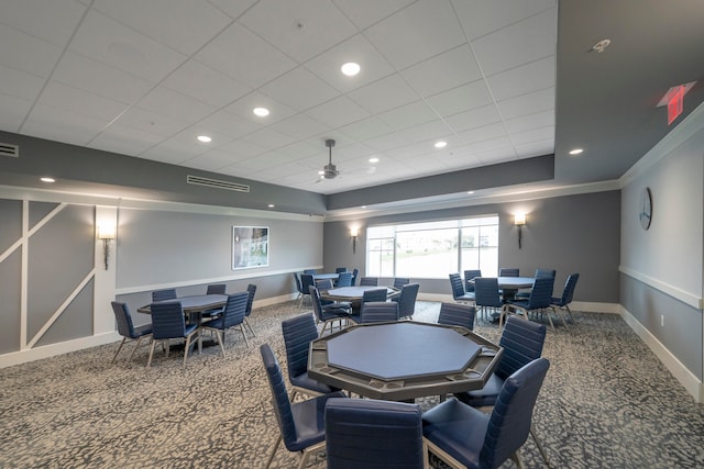 carpeted dining room featuring ornamental molding and ceiling fan