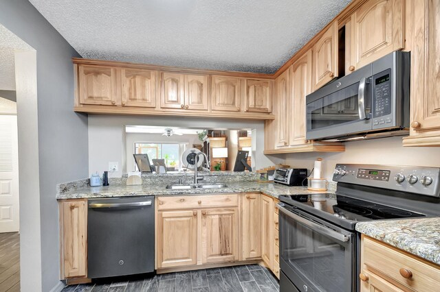 kitchen featuring light stone countertops, sink, stainless steel appliances, dark hardwood / wood-style floors, and a textured ceiling