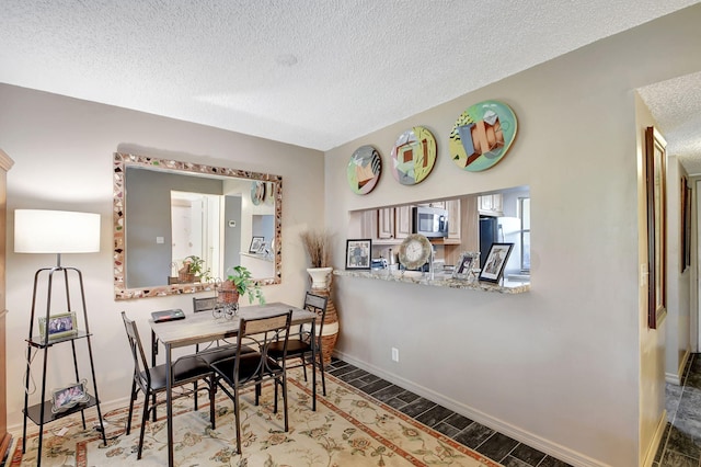 dining area featuring dark hardwood / wood-style floors and a textured ceiling