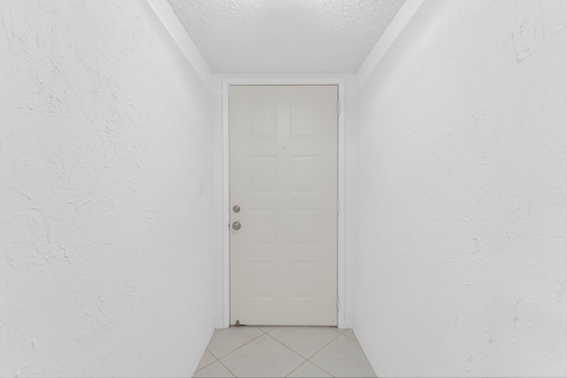 interior space featuring a textured ceiling and light tile patterned floors