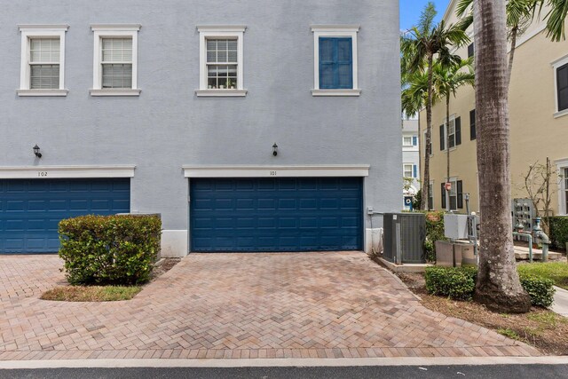 view of front facade with a garage and central air condition unit